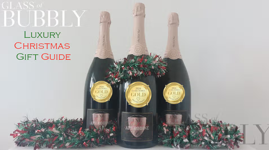 Glass of Bubbly - Luxury christmas gift guide. Three bottles of Aphrodise decorated with Christmas decorations