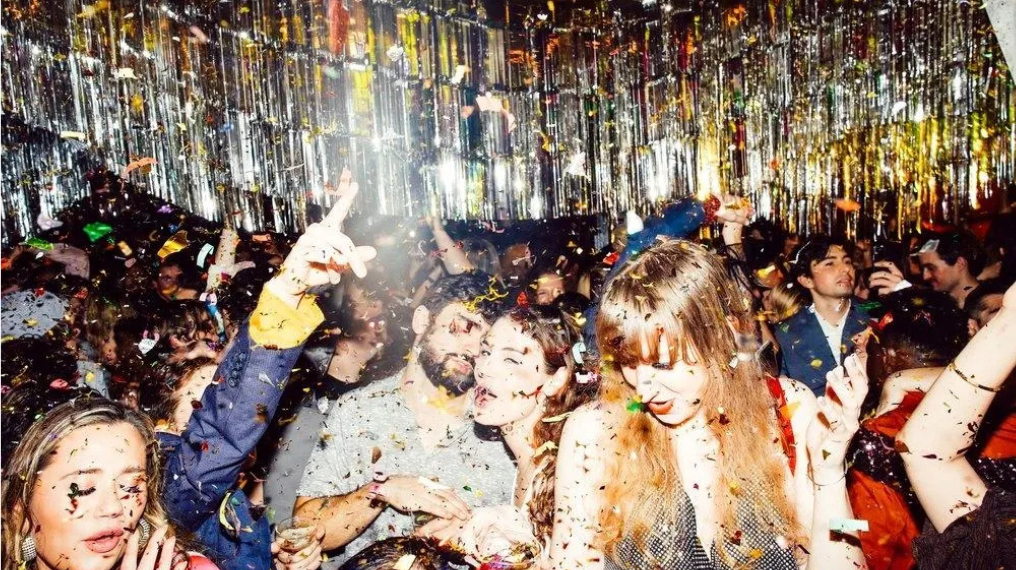 A group of people partying with confetti falling around them