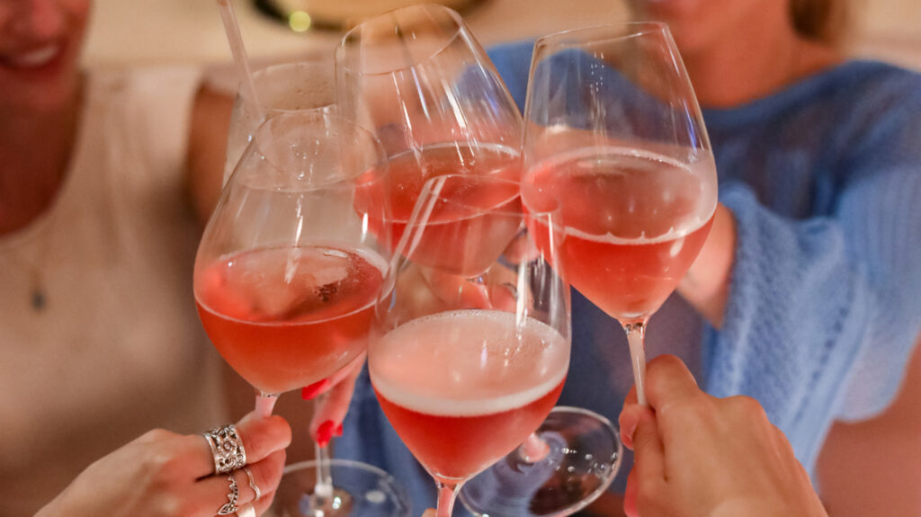 A group of people cheersing glasses of Aphrodise