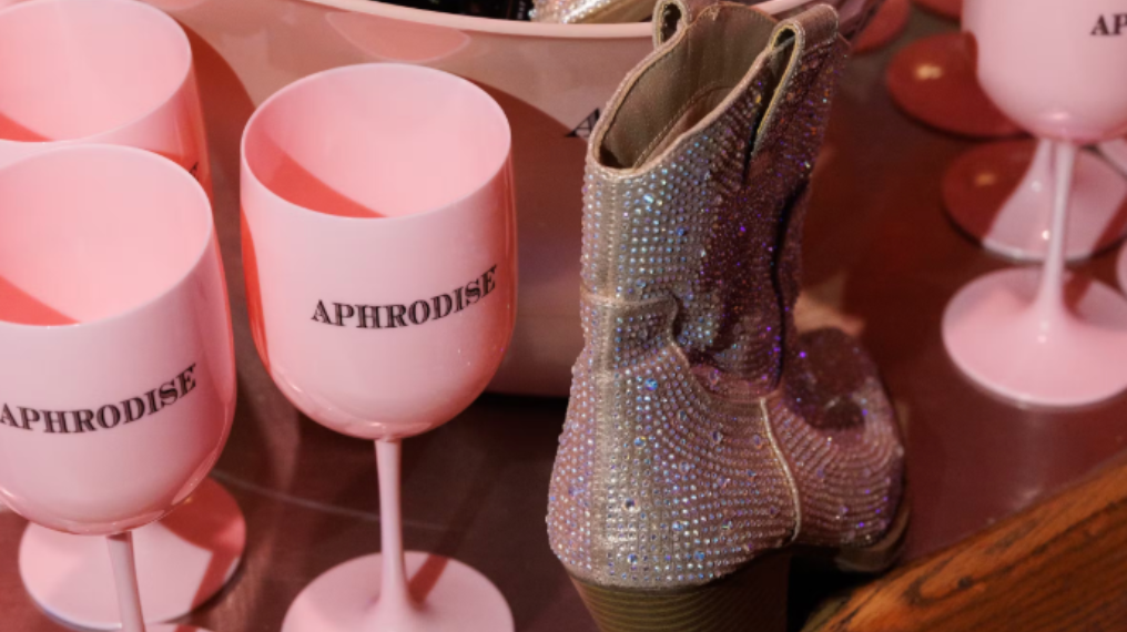Close up of sparkly boot next to pink drink aphrodise wine glasses
