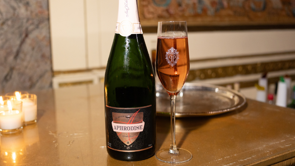 Drink Aphrodise bottle next to a flute glass full of Aphrodise